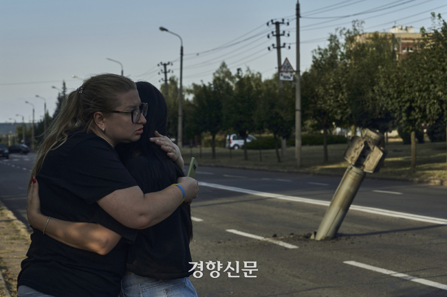 우크라이나 도네츠크주 크라마토스크 주민들이 지난 9월2일(현지시간) 러시아 공습 후 로켓 잔해 옆에서 포옹하고 있다. AP연합뉴스