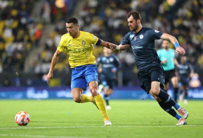 알나스르의 크리스티아누 호날두(왼쪽)가 25일(한국시간) 사우디아라비아 리야드에서 열린 사우디아라비아 프로축구 경기에서 수비수를 따돌리고 있다. 로이터 연합뉴스