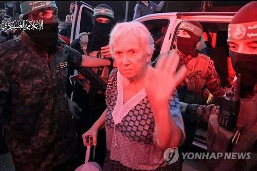 풀려나는 이스라엘 인질 (가자지구 AFP=연합뉴스) 24일(현지시간) 팔레스타인 가자지구에서 하마스에 의해 국제적십자사로 인계되는 이스라엘 여성 인질이 손을 흔들고 있다. 이날 하마스는 1차로 이스라엘 인질 13명과 태국·필리핀 인질 11명 등 모두 24명의 인질을 석방했다. 2023.11.25