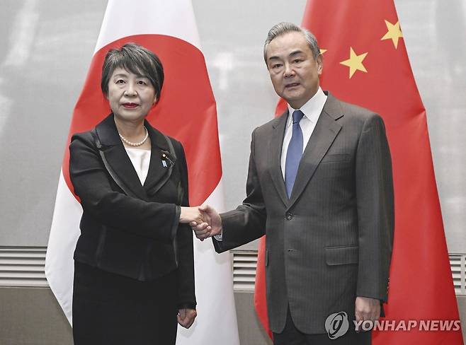 부산에서 만난 중일 외교수장 (부산 교도·AP=연합뉴스) 왕이 중국 외교부장(오른쪽)과 가미카와 요코 일본 외무상이 25일 부산에서 만나 악수하고 있다.