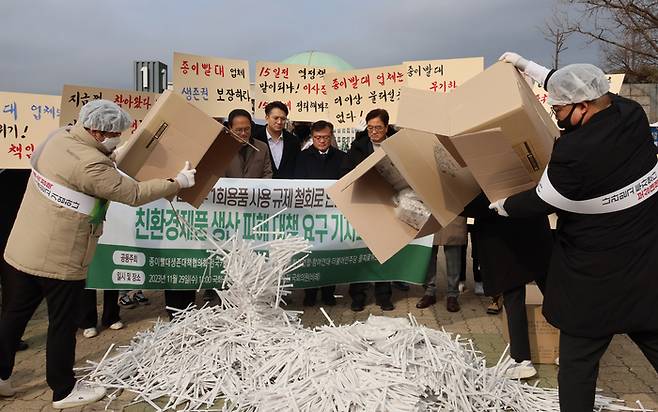 29일 국회 앞에서 더불어민주당 을지로위원회와 종이빨대생존대책협의회, 전국카페사장협동조합 등이 기자회견을 열고 환경부 1회용품 사용 규제 철회로 인한 친환경제품 생산 피해 대책을 촉구하며 종이빨대를 바닥에 쏟아내고 있다. 연합뉴스.