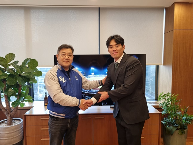 22일 삼성과 FA 계약을 체결한 김재윤(왼쪽)이 유정근 대표이사과 악수를 나누고 있다. /사진=삼성 라이온즈 제공