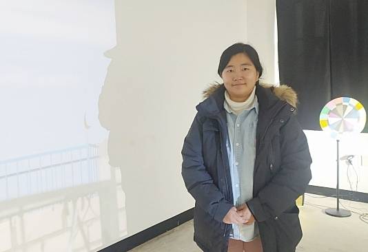‘2023 이주민 이야기’ 전시장에서 사진을 찍고 있는 김양우 작가 뒤편으로 김 작가가 카자흐스탄에서 촬영한 영상이 흐르고 있다. 정자연기자