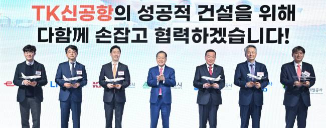 지난 20일 서울 영등포구 페어몬트 앰배서더 호텔에서 열린 ‘대구경북(TK)신공항 투자설명회’에서 홍준표(가운데) 대구시장이 신공항 건설 협력사 관계자들에게 비행기 모형을 선물한 뒤 기념사진을 촬영하고 있다.  대구시청 제공