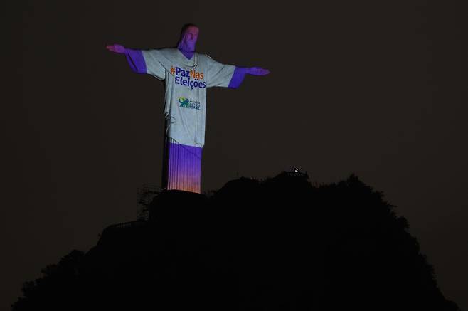 지난 1일 브라질 대선 전날 리우 데 자네이루를 상징하는 '구세주 그리스도상'이 "평화 속에 선거를 치르기를"란 문구로 불밝혀져 있다. 보우소나루 정권의 대선 불복에 따른 소요 사태가 우려되고 있다. /AFP 연합뉴스