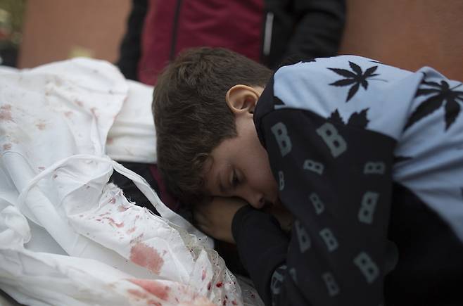 1일(현지시간) 이스라엘과 하마스 간 휴전 종료로 이스라엘군의 공습이 재개되자 남부도시 칸유니스에서 아버지를 잃은 아이가 시신을 안고 울고 있다. EPA연합뉴스