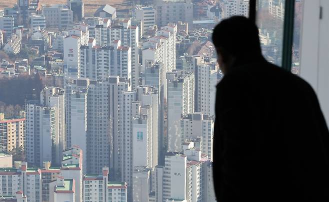 서울 송파구 롯데월드타워 전망대를 찾은 관람객이 아파트 단지를 바라보고 있다. 뉴스1