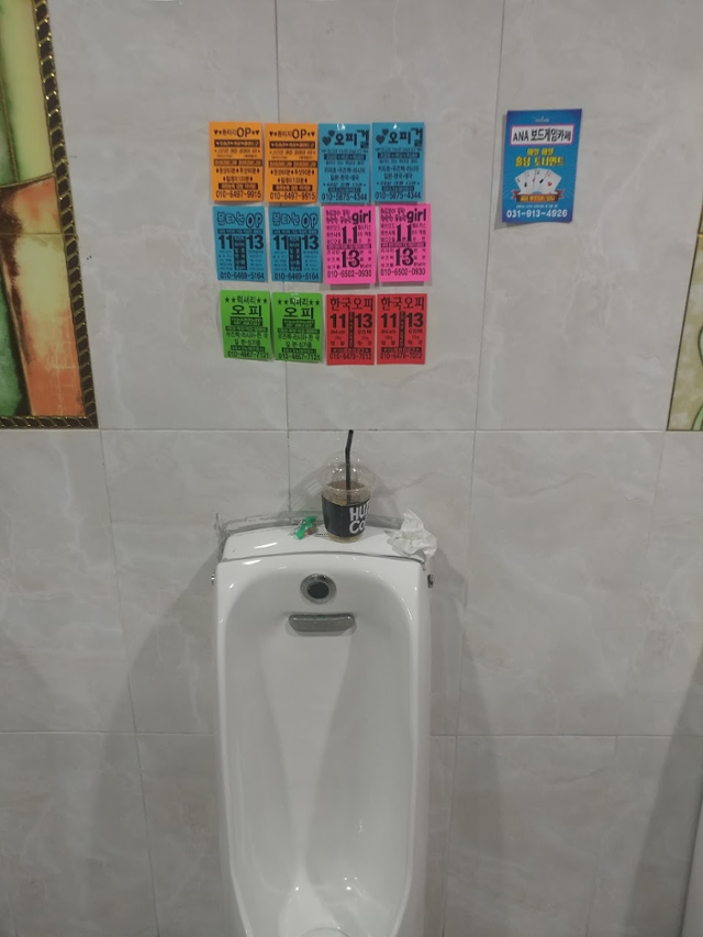 경기 고양시의 한 상가 건물 남자 화장실에 소변기 위에 성매매 광고 전단지가 붙어 있다. 이한 작가