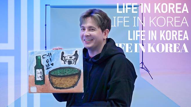 Levene holds his painting from his interview for "Life In Korea." (The Korea Herald)