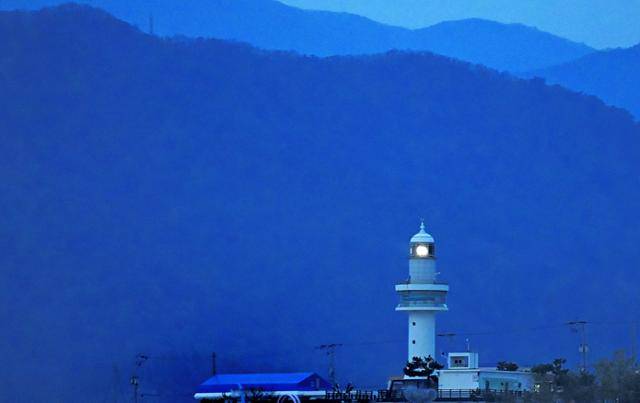 강원 동해시 묵호등대 불빛이 이른 새벽 거친 바다 풍랑 속에 조업하는 어부를 위로하고 있다.