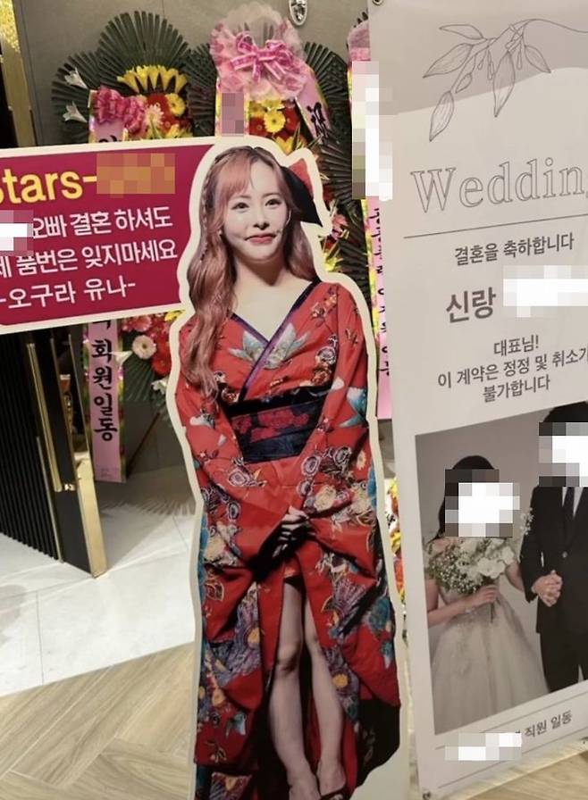 지난 3일 한 온라인 커뮤니티에 '일본 성인배우 오구라 유나의 등신대가 신랑 측 화환과 함께 놓여 있었다'는 내용의 SNS 게시글이 공유됐다. 등신대 상단에는 해당 배우가 출연한 음란 영상의 번호가 공개돼 있었다. (사진=SNS 갈무리) *재판매 및 DB 금지