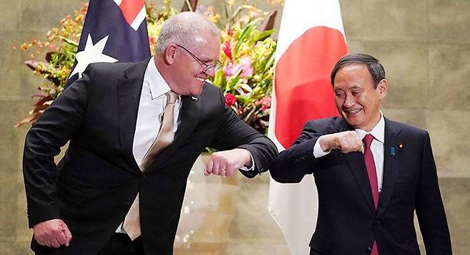 17일 일본 도쿄 총리관저를 찾은 스콧 모리슨(왼쪽) 호주 총리가 스가 요시히데 일본 총리와 팔꿈치 인사를 나누고 있다. /AP 연합뉴스