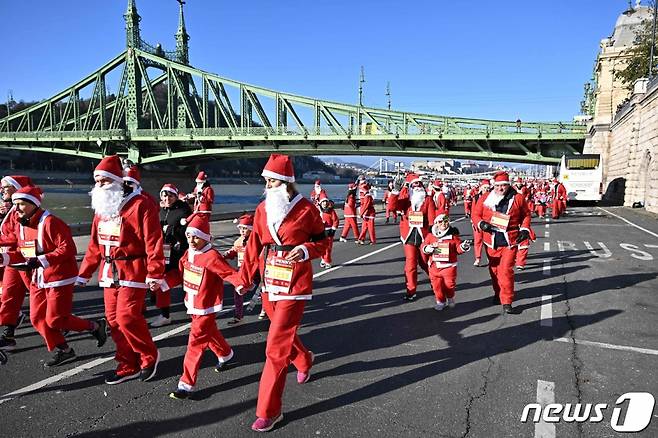 (부다페스트 AFP=뉴스1) 최종일 기자 = 3일(현지시간) 헝가리 부다페스트 시내에서 열린 산타클로스 달리기 대회에서 산타클로스 복장을 한 참가자들이 달리기를 하고 있다. 2023.12.03  ⓒ AFP=뉴스1  Copyright (C) 뉴스1. All rights reserved. 무단 전재 및 재배포,  AI학습 이용 금지.