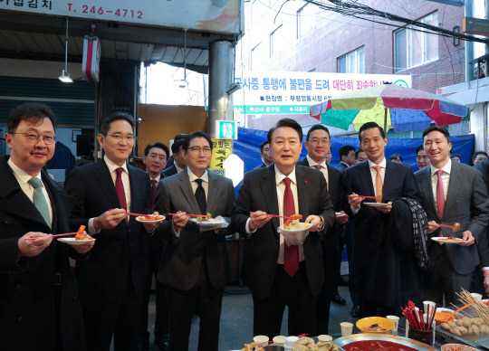 윤석열 대통령이 6일 부산 중구 깡통시장에서 재계 총수들과 분식을 맛보고 있다. 왼쪽부터 최재원 SK 수석부회장, 이재용 삼성전자 회장, 조현준 효성그룹 회장, 윤 대통령, 구광모 LG그룹 회장, 김동관 한화 그룹 부회장, 정기선 HD현대 부회장.  [대통령실 제공]