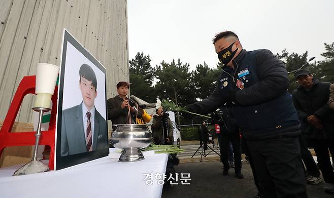 추모제 참가자들이 고 김용균 씨가 숨진 사고 현장 외벽에 마련된 영정에 헌화하고 있다.