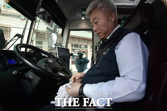 버스 기사가 장갑을 끼며 마지막 운행을 준비하고 있다.