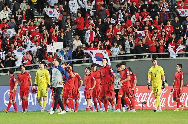 한국 U-20(20세 이하) 축구 대표팀이 9일 아르헨티나 라플라타 우니코 디에고 아르만도 마라도나 경기장에서 이탈리아와 벌인 U-20 월드컵 4강전에서 1대2로 패한 후 아쉬워하는 가운데, 한국 팬들이 태극기를 흔들며 선수들을 격려하고 있다. 2019년 대회에 이어 2연속 결승 진출은 실패했지만 한국은 12일 이스라엘과 3·4위 결정전에서 유종의 미를 노린다. /뉴스1