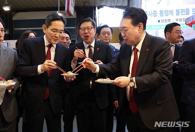 윤석열 대통령이 6일 부산 중구 깡통시장을 방문해 이재용 삼성전자 회장에게 빈대떡을 나눠주고 있다. (대통령실통신사진기자단)