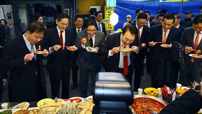 윤석열 대통령과 이재용 삼성전자 회장 등 재계 총수들이 지난  6일 부산 중구 깡통시장을 방문해 떡볶이를 시식하는 장면. [사진출처=대통령실사진기자단]