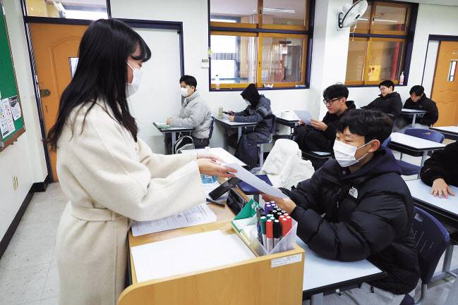 2024학년도 대학수학능력시험 성적표 배부일인 8일 오전 서울 종로구 경복고에서 3학년 학생이 교사로부터 성적표를 받고 있다. [사진공동취재단]