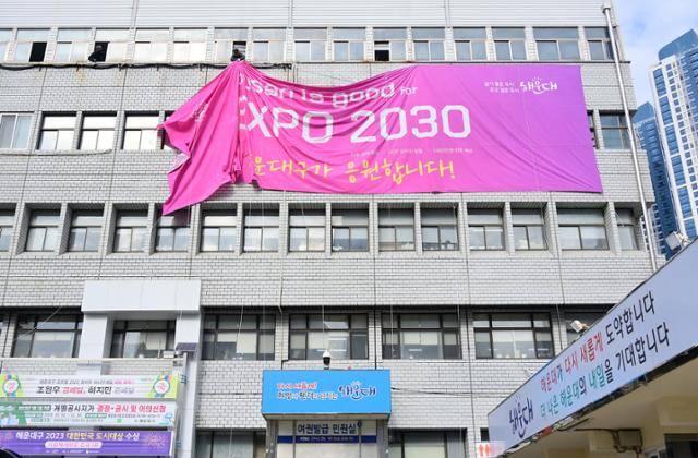 사우디아라비아 리야드가 2030세계박람회 개최지로 결정된 이튿날인 지난달 29일 부산 해운대구청 외벽에 걸려 있던 '2030세계박람회 부산 유치' 응원을 위한 현수막이 철거되고 있다. 해운대구청 제공