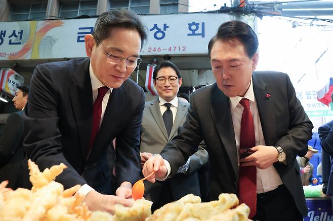 윤석열 대통령과 이재용 삼성전자 회장이 6일 부산 중구 깡통시장에서 떡볶이, 만두 등 분식을 시식하고 있다. [연합]