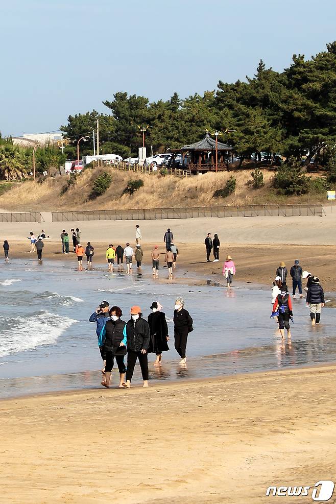 10일 오후 제주시 이호테우해수욕장에서 나들이객들이 맨발로 해변을 거닐고 있다.이날 오후 2시 기준 제주 낮 최고기온은 23.1도를 기록했다.2023.12.10./뉴스1 ⓒ News1 오미란 기자