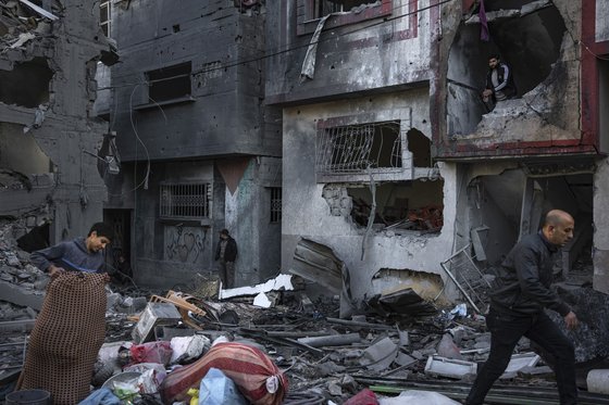 이스라엘의 공습을 받은 라파의 한 주택가에서 무엇인가를 찾고 있는 팔레스타인 사람들.AP=연합뉴스