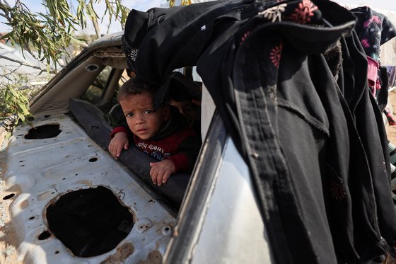 고장난 자동차 속에서 밖을 바라보고 있는 아이. 8일 라파에서 찍은 사진이다. 로이터=연합뉴스