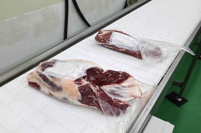 작업을 마쳐 소분된 부위가 진공 포장된 채로 컨베이어벨트로 이동하고 있다.