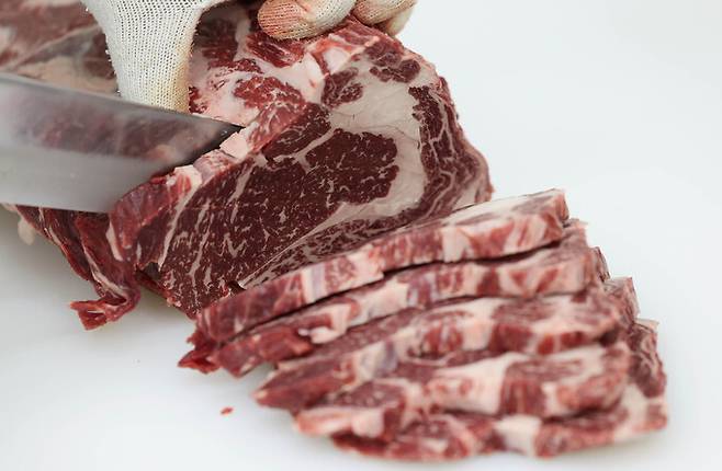 미트센터에서 농협하나로마트 축산매장으로 옮겨진 한우 등심 부위를 자르고 있다.