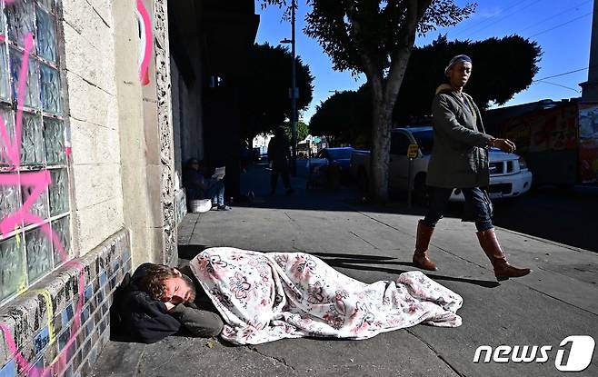 한 노숙자가 지난달 22일(현지시간) 미국 로스 앤젤레스의 도로 위에서 잠을 자고 있다. 2023.11.23 ⓒ AFP=뉴스1 ⓒ News1 정지윤 기자