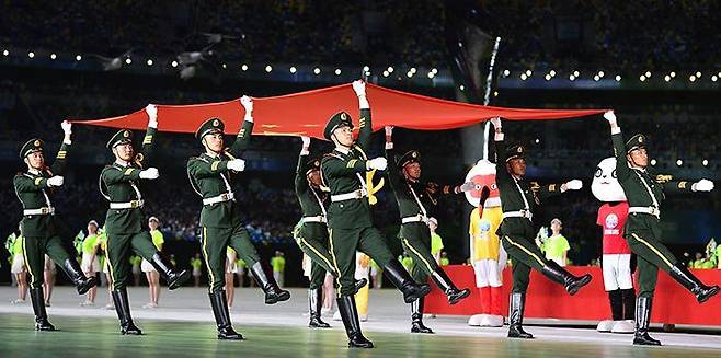中 ‘노마스크’ 전국체전 - 중국 시안에서 15일 열린 제14회 전국체육대회 개막식에서 군인들이 마스크를 쓰지 않은 채 대형 중국 국기를 들고 행진하고 있다. 이날 시진핑 국가주석을 비롯한 귀빈들과 선수단, 공연자들도 마스크를 쓰지 않았다. /AFP 연합뉴스
