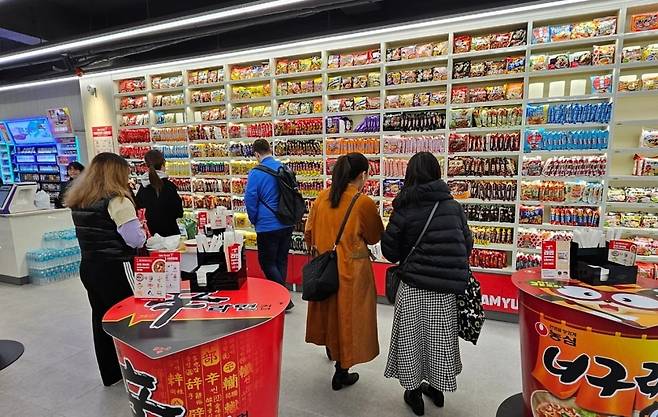 지난 10일 서울 서교동 CU홍대상상점에서 외국인 관광객들이 라면을 고르고 있다./ 김동주 기자