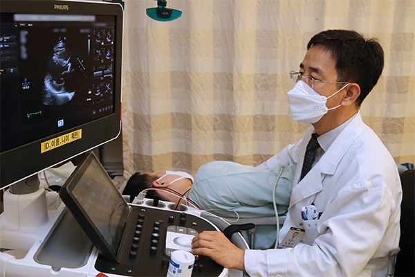 Professor Song Jong-Min, the President of AMC Heart Institute, is conducting an echocardiogram on a patient with valvular heart disease.