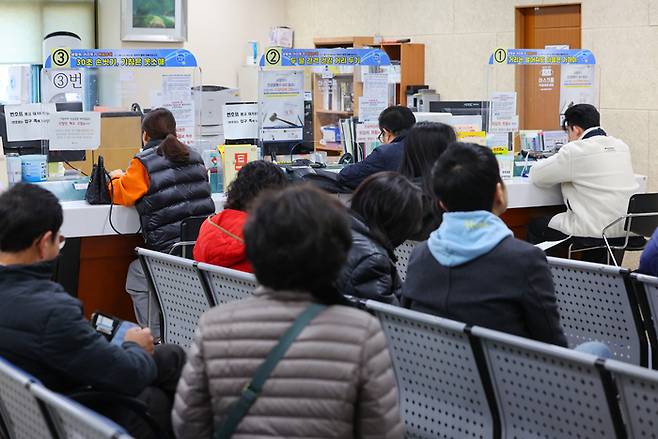 지난 20일 오전 서울 동작구 상도1동주민센터를 찾은 시민들이 순서를 기다리고 있다. <자료 = 연합뉴스>
