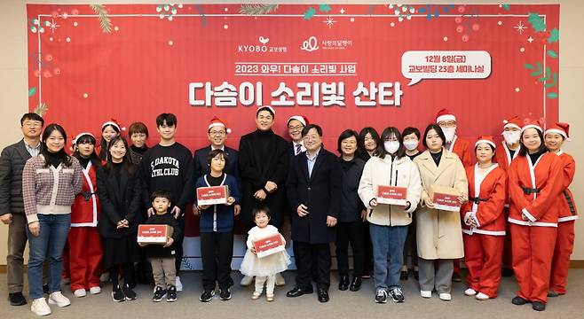 8일 서울 종로구 교보생명빌딩에서 열린 '다솜이 소리빛 산타' 행사에서 교보생명 및 사랑의달팽이 관계자, 자원봉사자, 수혜아동 가족이 기념촬영을 하고 있다. 교보생명 제공