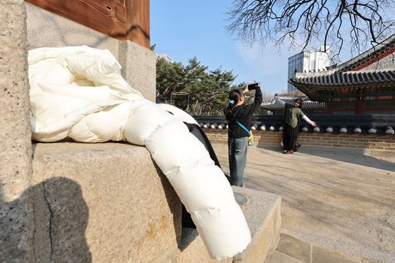 예년보다 온화한 날씨가 이어진 5일 오후 서울 덕수궁에서 외국인 관광객들이 겉옷을 벗어둔 채 기념 촬영을 하고 있다. 뉴스1