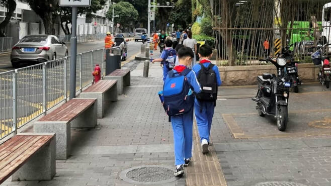 중국 광동성에서 초등학생들이 가방을 매고 학교로 가고 있다. [로이터]