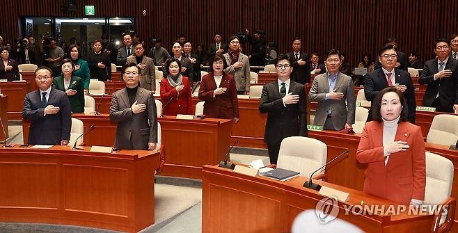 국민의힘 정책의원총회 (서울=연합뉴스) 한종찬 기자 = 국민의힘 윤재옥 원내대표와 한동훈 법무부 장관 등이 6일 국회 예결위회의장에서 열린 국민의힘 정책의원총회에서 국민의례를 하고 있다. 2023.12.6 saba@yna.co.kr