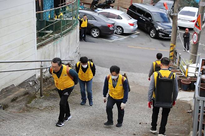 장일현 부산지방국세청장(왼쪽 첫번째)이 부산 연제구 연산2동 일대 연탄을 필요로 하는 가구에 직원들과 함께 직접 배달하고 있다. 부산지방국세청 제공