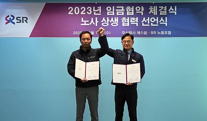 이종국 에스알 대표(오른쪽)와 김상수 에스알 노동조합 위원장이 13일 2023년도 임금협약 합의 후 9년 연속 무분규 체결을 달성하고 기념 촬영을 하고 있다. 에스알 제공