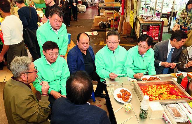 이승열 하나은행장(왼쪽에서 두번째)이 강성묵 하나증권 대표이사(그룹 부회장, 오른쪽에서 두 번째), 이호성 하나카드 대표이사(오른쪽에서 세 번째)와 서울 광장시장 내 한 노점에서 시장 상인들의 애로사항을 청취하고 있다./사진=하나금융  '