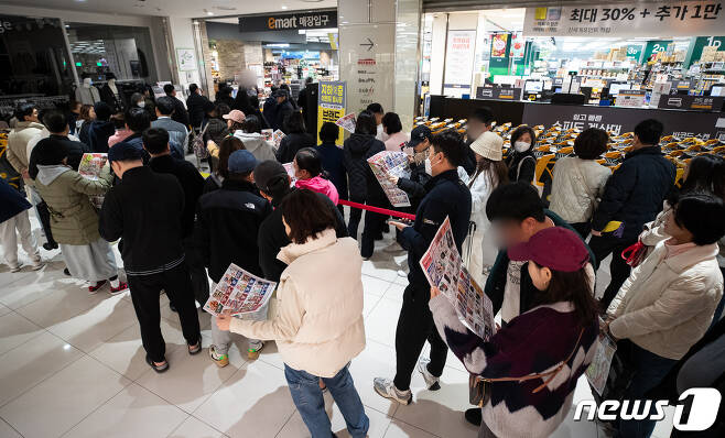 19일 서울 이마트 영등포점을 찾은 고객들이 매장 개장 시간 전에 입장을 위해 길게 줄지어 서서 행사 전단을 살펴보고 있다.  2023.11.19/뉴스1 ⓒ News1 유승관 기자