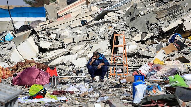 잔해 더미에 앉아 있는 가자지구 주민 [사진 제공: 연합뉴스]
