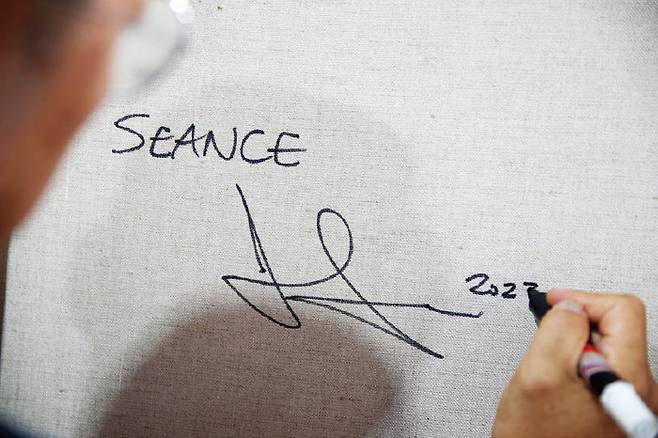 진 마이어슨 작가가 캔버스 뒷면에 서명하고 있다. [지호영 기자]