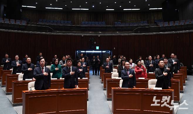 국민의힘 윤재옥 당대표 권한대행을 비롯한 의원들이 15일 오전 국회에서 열린 긴급 의원총회에 참석해 국민의례하고 있다. 황진환 기자