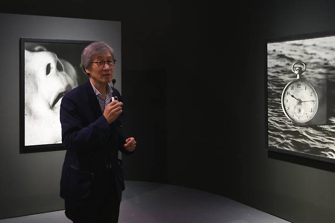 구본창 작가가 13일 서울 중구 서울시립미술관에서 열린 ‘구본창의 항해’ 전시 기자간담회에서 병상의 아버지를 촬영한 ‘숨’ 앞에서 작품에 대해 설명하고 있다. 연합뉴스