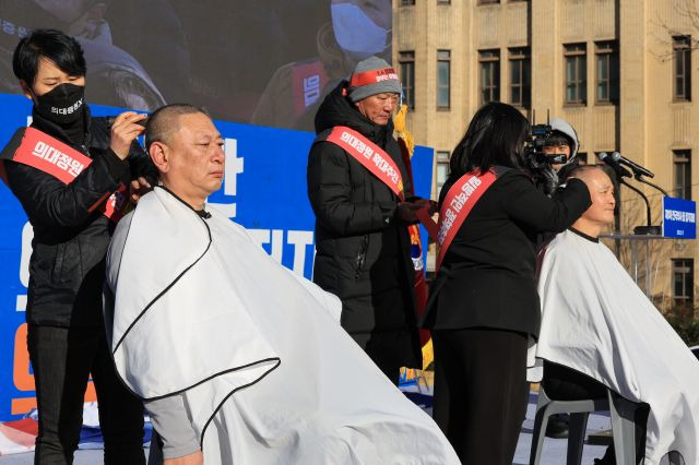 17일 오후 서울 동화면세점 인근 세종대로에서 대한의사협회 '대한민국 의료붕괴 저지를 위한 범의료계대책특별위원회' 주최로 열린 전국의사총궐기대회에서 이정근 의협 상근부회장(왼쪽)과 길광채 범대위 위원이 삭발하고 있다. 연합뉴스