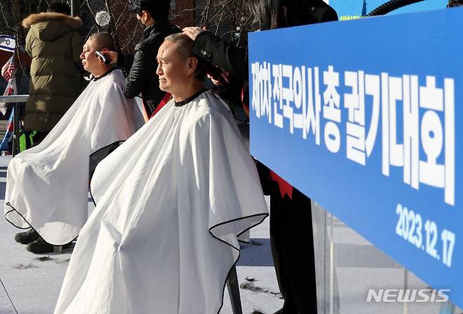 [서울=뉴시스] 배훈식 기자 = 이정근(왼쪽) 대한의사협회 상근 부회장과 김광채 광주 서구의사회 회장이 17일 오후 서울 종로구 동화면세점 앞에서 열린 '의료붕괴 저지를 위한 '제1차 전국 의사 총궐기 대회'에 참석해 의과대학 정원 정책 폐기를 촉구하며 삭발하고 있다. 2023.12.17. dahora83@newsis.com